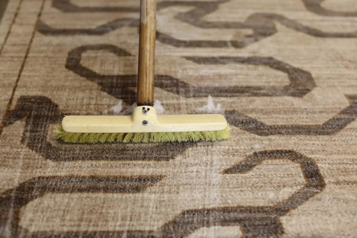 Brossage soigneux d’un tapis clair à motifs